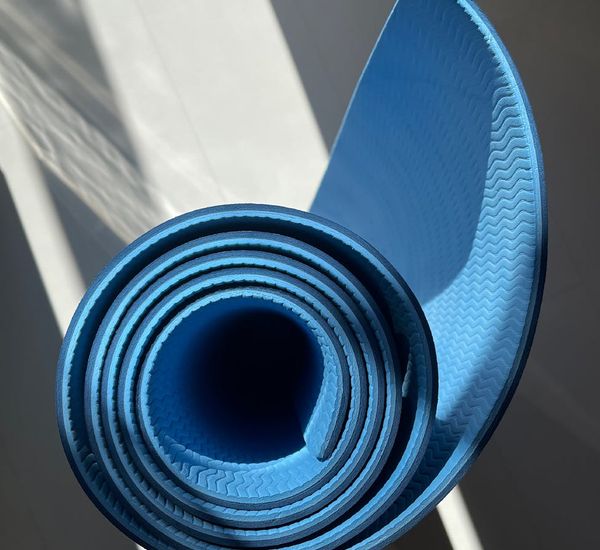 Yoga mat rolled out on the floor, ready for practice.
